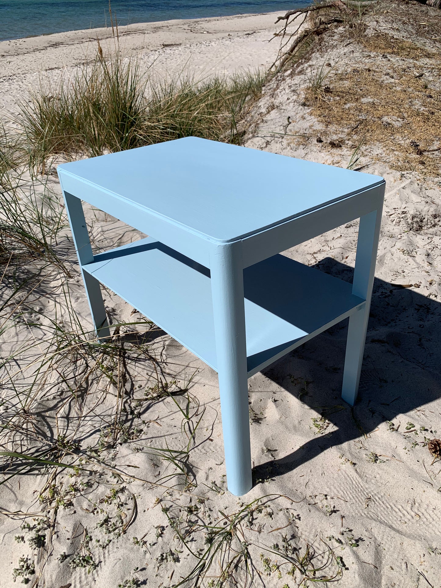 Hellblauer Tisch mit Regal